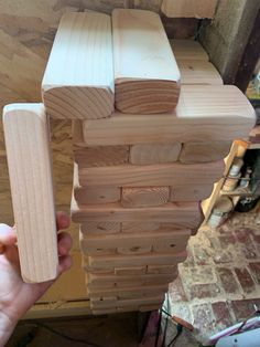 a person holding a stack of wooden boards in their hands, with the top half being made out of plywood