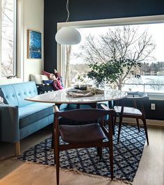 a living room filled with furniture and a large window overlooking the water's edge