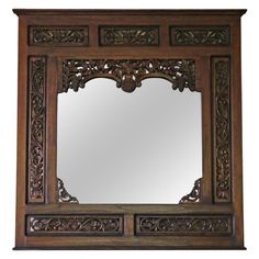 an ornate wooden mirror with carvings on it