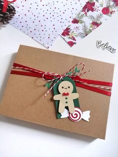 a christmas card with a paper cut out of a gingerbread man holding a candy cane