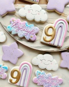 cookies decorated with pastel colors and gold numbers are on a platter next to other decorations