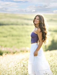 a beautiful young woman standing in a field