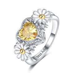 a heart shaped ring with flowers on the side and an orange stone in the center