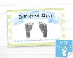 a baby's hand and foot print on a card with a blue ribbon around it