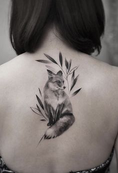 the back of a woman's neck with a tattoo of a fox on it