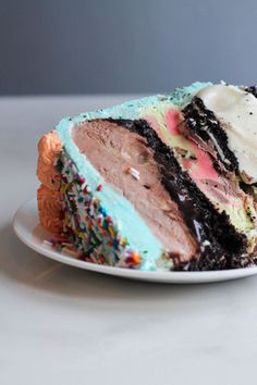 a slice of cake with sprinkles and frosting on a white plate