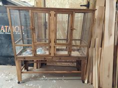 an old wooden bird cage sitting next to some wood planks