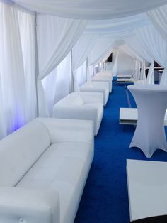 white couches and tables in a room with blue carpeted flooring on both sides