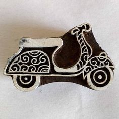 a metal brooch with an intricate design on the front and back of it, sitting on a white surface