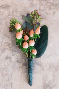 a bunch of flowers that are sitting on a counter top with green leaves and buds