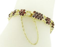 A stunning, rich, bountiful presentation of the garden's most precious blossoms, this Victorian natural bohemian garnet floral bracelet in 18K yellow gold vermeil over sterling silver is a beautiful treasure, sure to pamper you elegantly whenever you wear it. 16 Flowers of brilliant, fiery securely prong and bezel set garnets ( January Birthstone ) are made up of 124 red round rose cut pyrope garnets, for a grand total of 12.5 carats for the piece! This luxurious bracelet measures 5/16 inch high Elegant Garnet Jewelry With Filigree, Luxury Garnet Bracelets For Gift, Luxury Garnet Jewelry With Intricate Design, Red Garnet Filigree Jewelry, Ornate Red Garnet Jewelry, Pyrope Garnet, Natural Bohemian, Floral Bracelet, Bezel Setting