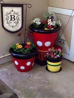 three mickey mouse flower pots sitting on the ground