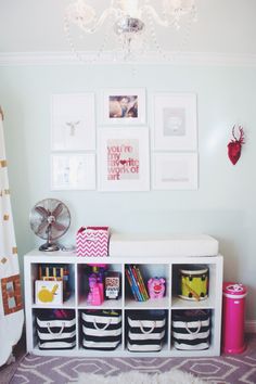 a baby's room with toys and pictures on the wall