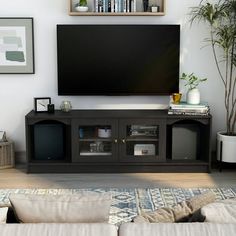 a flat screen tv sitting on top of a wooden entertainment center in a living room