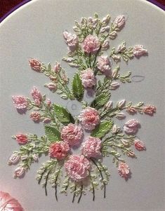 a white plate topped with pink flowers and green leaves