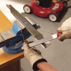 a person using a pair of scissors to cut something on a piece of wood next to a toy car