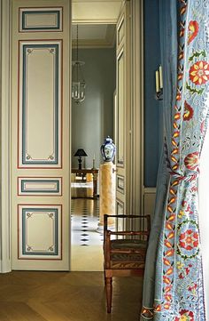 an open door leading into a room with blue walls and wood flooring on either side