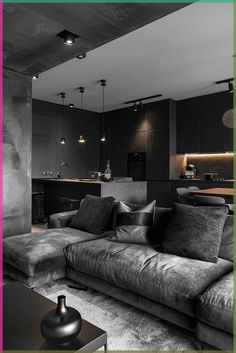 a black and white photo of a living room with couches, coffee table and kitchen in the background