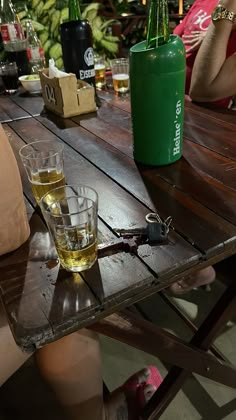 a wooden table topped with glasses and bottles