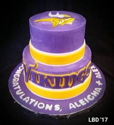 a purple and yellow cake with the word vikings on it's side, in front of a black background