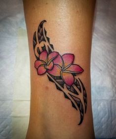 a woman's foot with a pink flower tattoo on the side of her leg