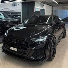 a black car parked in a garage next to other cars