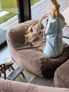 a woman laying on top of a bean bag chair