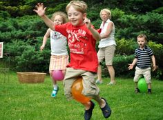 a group of children playing with balls in the grass