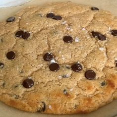 a chocolate chip cookie sitting on top of a piece of parchment paper in a box