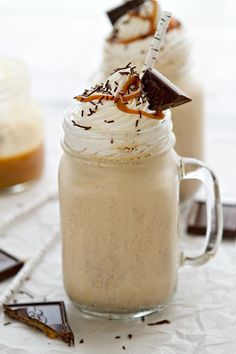 two desserts in glass mugs sitting on a table