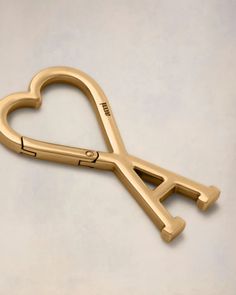 a gold heart shaped scissors on a white surface