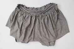 a pair of gray shorts sitting on top of a white wall