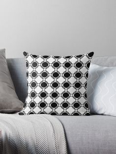 a black and white throw pillow sitting on top of a gray couch next to pillows