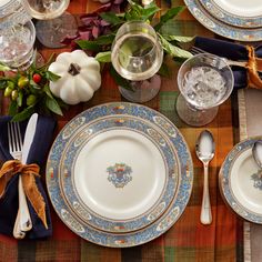 the table is set with plates, silverware and flowers