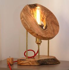 a wooden table with a lamp on it and a red cord plugged into the light