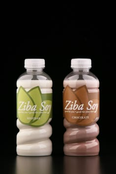 two bottles of liquid sitting side by side on a black surface, one containing zibaa soy and the other containing chocolate