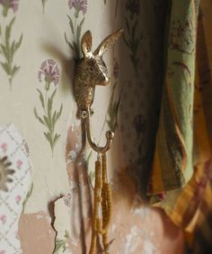 a deer head mounted to the side of a wall next to a flowered curtain