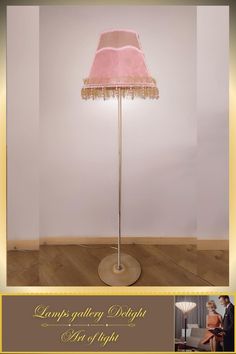 a pink lamp shade on top of a wooden floor