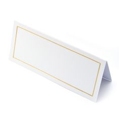 a white and gold place card holder on a white background with an empty space in the middle