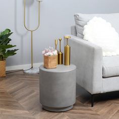 a living room with a couch, chair and vases on the floor in front of it