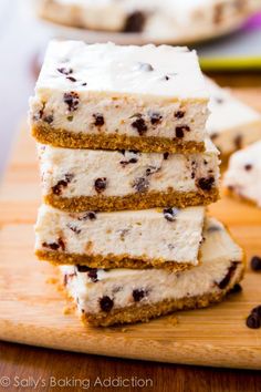 three pieces of cake sitting on top of a wooden cutting board next to each other