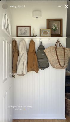 an entryway with several coats and purses hanging on the wall next to it