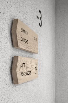 two wooden signs mounted to the side of a wall