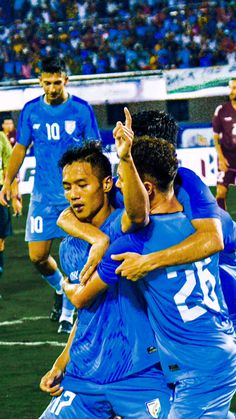 two soccer players are hugging each other on the field