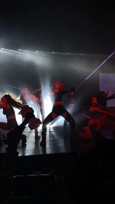 a group of dancers performing on stage at a concert