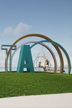 two people are sitting on a bench in front of the letters at an art museum