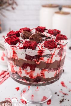 a dessert with red and white icing on it is in a glass dish that says vampire halloween trifle