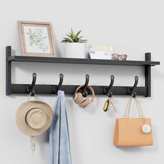 a wall mounted shelf with hats, purses and other items hanging on the hooks