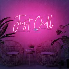 two wicker chairs in front of a neon sign that says just chill