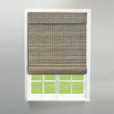 a window with a brown roman blind in front of it